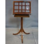 An Edwardian mahogany music stand, with drawer, raised on adjustable tripod base, some damage