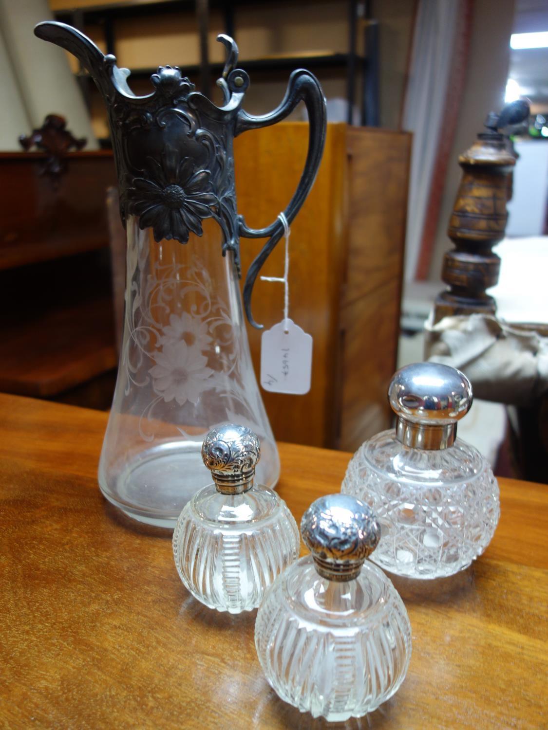 A pair of Victorian glass scent bottles with silver tops, together with a larger example by Mappin &