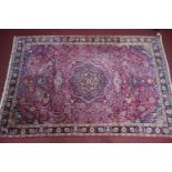 A Northeast Perisan Meshad carpet, double pendant medallion with repeating petal motifs on a rouge