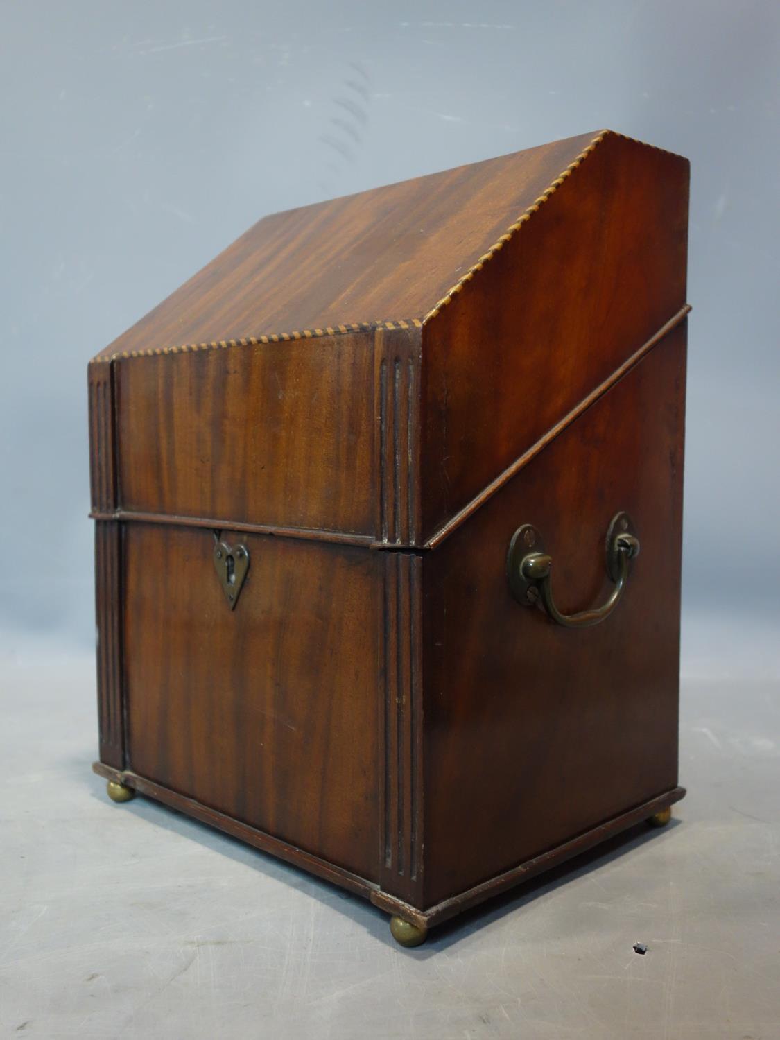 A Georgian inlaid mahogany stationery box, raised on brass ball feet, in the form of a writing