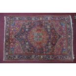 A 20th century Persian Bidjar rug, with central floral medallion, on a red and blue ground,