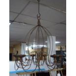 An antique wrought iron 9 branch chandelier for candles, lacking one sconce. 108cm H x 75cm W