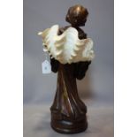 An early 20th century French bronze nun, converted to a lamp with a sea shell shade, H.54cm