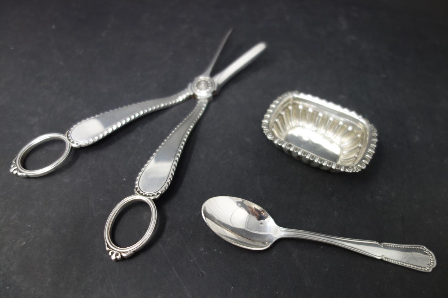 A collection of silver, to include two napkin rings, a teaspoon, a small gadrooned dish, and an - Image 3 of 3