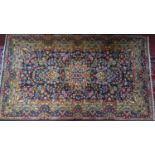 A Central Persian Kirman rug, central floral medallion with repeating petal motifs on a sapphire