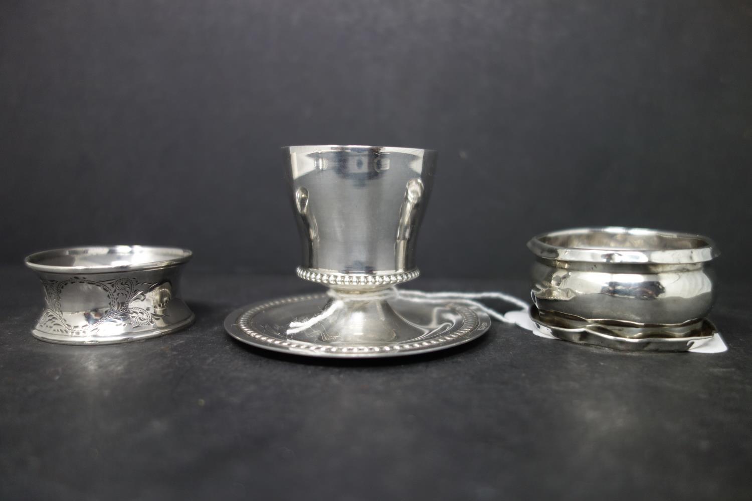 A collection of silver, to include two napkin rings, a teaspoon, a small gadrooned dish, and an - Image 2 of 3