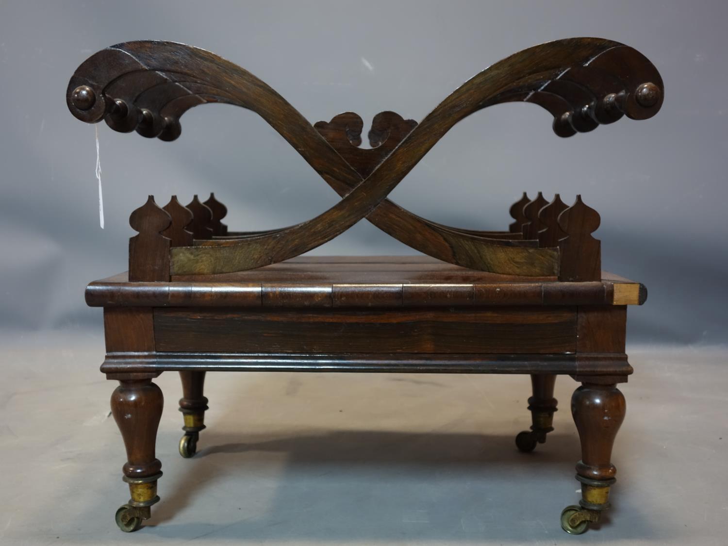 A late Regency rosewood Canterbury X-frame design, with drawer, raised on turned legs and castors,