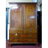 A late 18th century mahogany linen press, with 2 doors enclosing linen trays, above drawers,