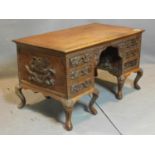 A 1920's/30's Chinese carved desk, carved with dragons and Chinese symbols, having six drawers, on