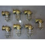 Seven vintage Industrial brass and glass bulkhead wall lights, one with broken glass, H.16 L.25cm
