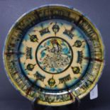 A Persian glazed ceramic bowl, decorated with a seated figure to center, dated and marked to base,