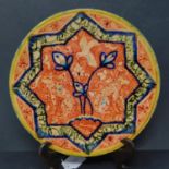 A Persian glazed ceramic dish, decorated with animals, flowers and birds, dated and marked to
