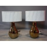 A pair of contemporary gilt table lamps, with oval cream shades, H.68cm