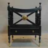 A Regency style black painted Canterbury, raised on turned legs and castors, H.64 W.48 D.38cm