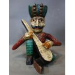 A carved wooden figure of a seated man with a turban playing the lute, H.45cm