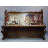 A Gothic oak mirror backed settle, raised on scrolling supports, H.133 W.171 D.38cm