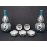 A Japanese boxed sake set, consisting of two pouring vessels, H.19cm, and five drinking cups, H.3.