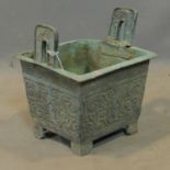 A Chinese archaic bronze incense burner, with twin handles and scrolling decoration, H.26 W.23 D.