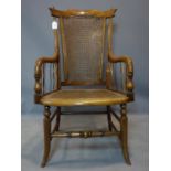 A late 19th century caned mahogany armchair, raised on splayed legs, joined by stretchers