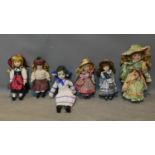 A collection of six porcelain dolls, to include by Leonardo Collection wearing a dress and bonnet,