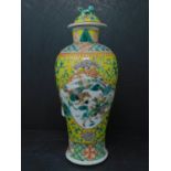 A 19th century Chinese famille jaune vase, the lid having Dog of Fo finial, decorated with vignettes