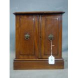 An early 20th century mahogany table top cabinet, with two doors revealing four short drawers