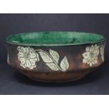 A large Chinese terracotta bowl, with green glazed interior and floral decoration to exterior,