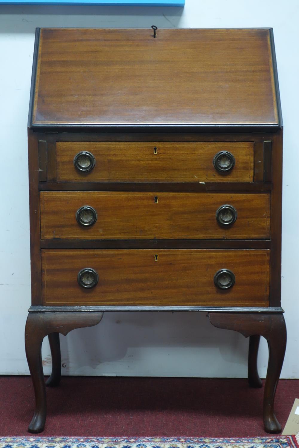 An inlaid mahogany bureau, with hinged lid and fitted interior above three drawers, on cabriole