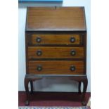 An inlaid mahogany bureau, with hinged lid and fitted interior above three drawers, on cabriole