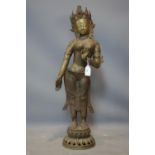 A Southeast Asian brass figure of a female deity on a lotus base, H.78cm