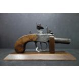 An antique Brasher flintlock pistol on stand
