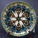 A Persian glazed ceramic dish, decorated with stylised floral motifs, marked and dated to base, H.
