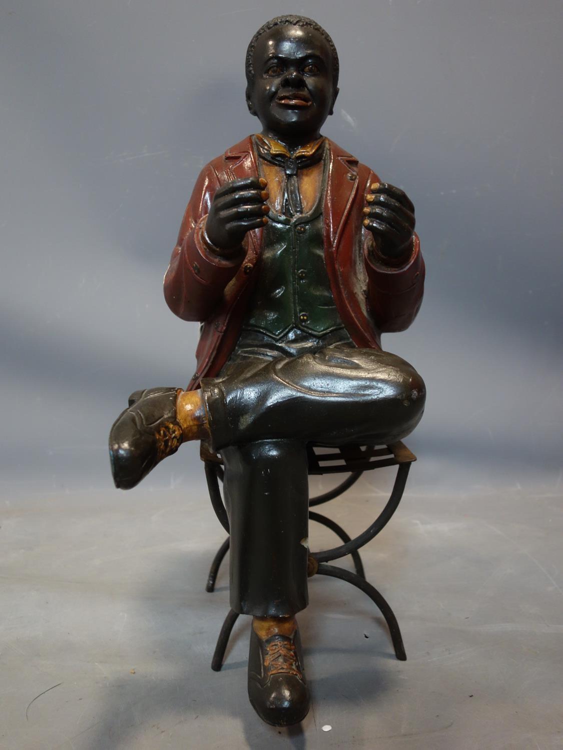 A fibreglass figure of a seated man, on a metal chair, H.55cm (man), H.43cm (chair)