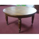 A Victorian walnut wind out dining table, raised on carved reeded legs and castors, with 2 extra