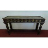 An Indian teak console table with embossed brass decoration and spandrels to the frieze on turned
