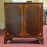 A Georgian inlaid two door mahogany cabinet, with marquetry fan paterae, on bracket feet, H.105 W.