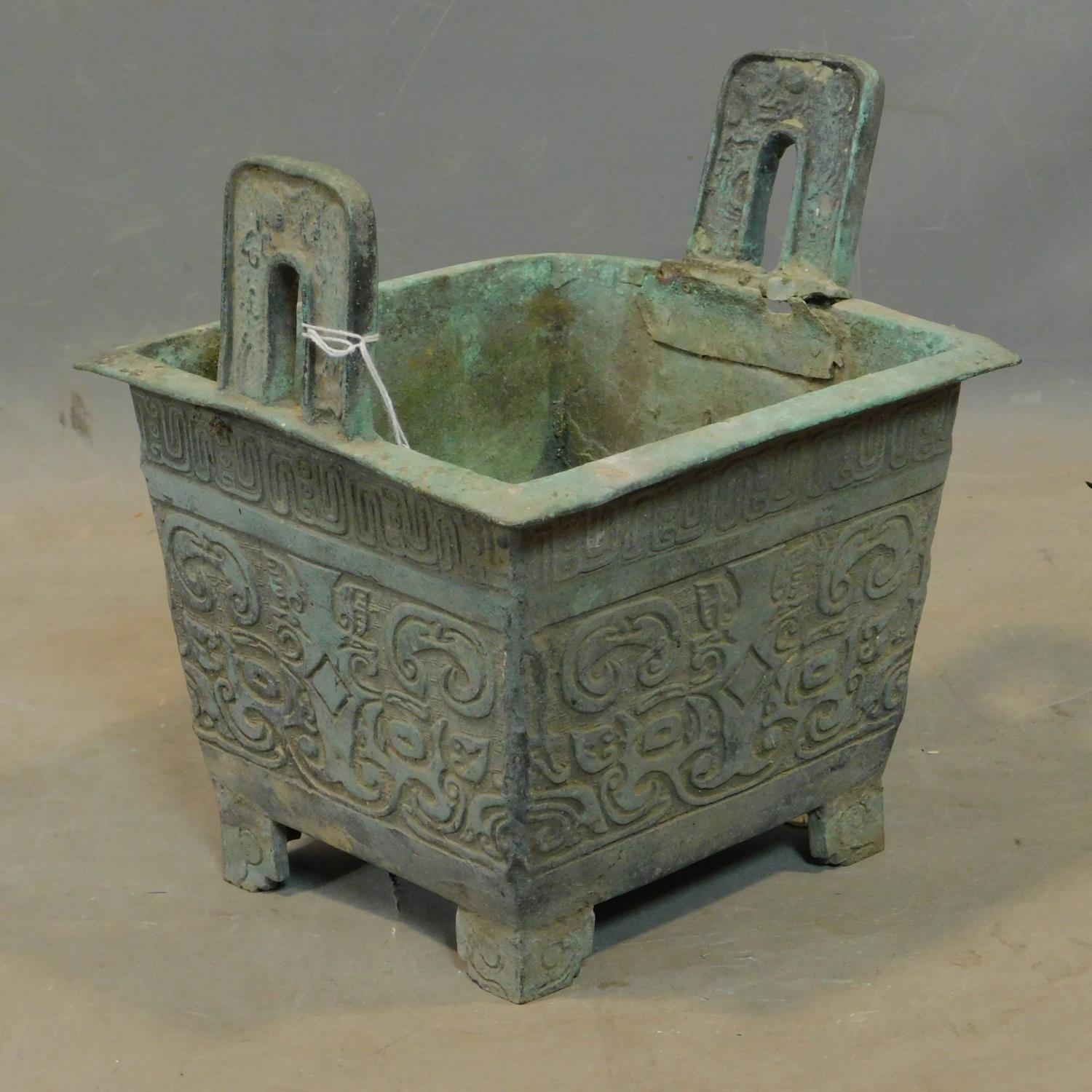 A Chinese archaic bronze incense burner, with twin handles and scrolling decoration, H.26 W.23 D.