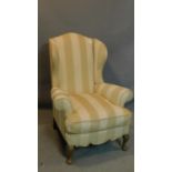 An early 20th century Georgian style wing back armchair
