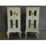 A pair of cream painted cabinets, with bevelled glass panelled doors, H.112 W.50 D.43cm