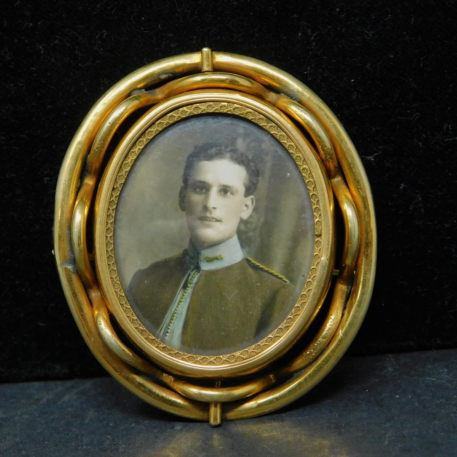 A 19th century pinchbeck brooch with double sided revolving picture frame, H.6cm, in associated box