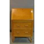 A mid 20th century light oak bureau, raised on splayed legs, H.104 W.62 D.41cm