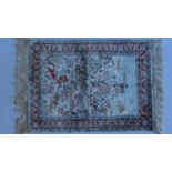 A small Persian silk rug, the central ground depicting men hunting on horseback contained in a