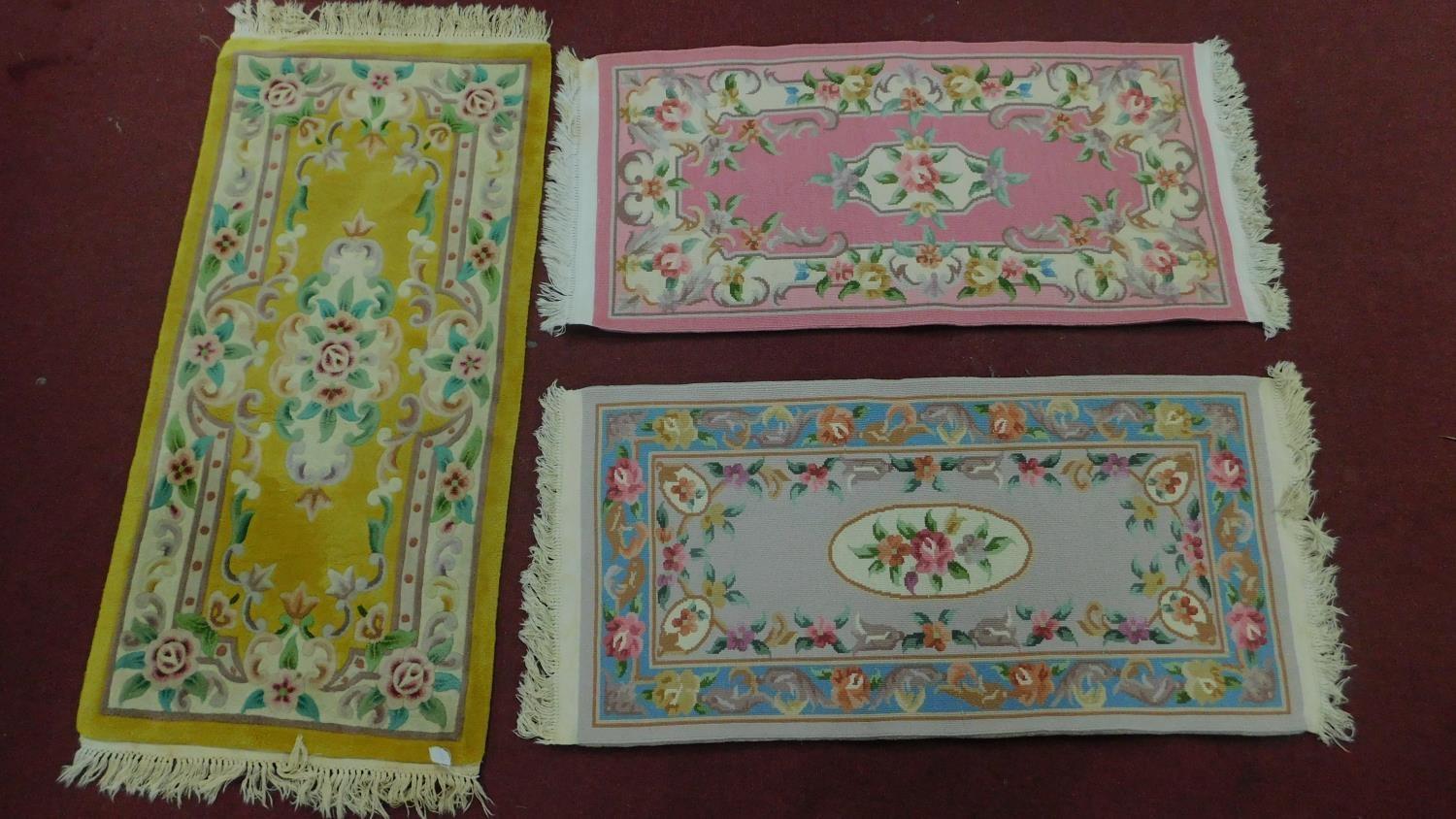 3 Chinese style rugs all set on a pastel field with central floral medallion within floral boarders.