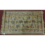 A Persian Qum style rug depicting a hunting scene with deer, set on an ivory field within a