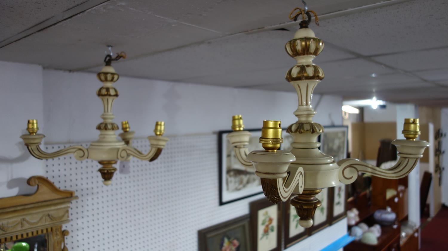 A pair of three branched painted wooden candelabras, the shades with tassels, H.40cm Diameter 43cm