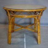 A circular bamboo dining table, with glass top, H.77cm Diameter 96cm