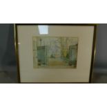 A framed and glazed watercolour of a garden scene signed Arnold Knight, label to verso. H.51 W.63