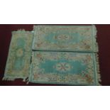 Three Chinese style floral rugs all set on a green field with central medallion within floral