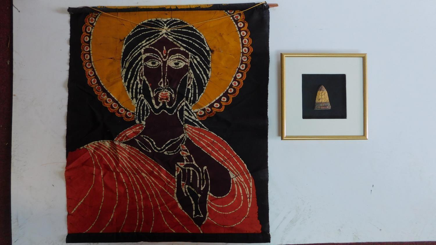 A framed and glazed carving of a deity and a religeous scroll. 72x62cm.