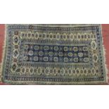 A Persian Turkoman Rug with repeating motifs, on a blue and cream ground with multi geometric